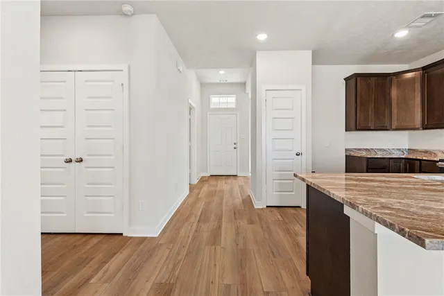 a kitchen with a wooden floor and electronic appliances