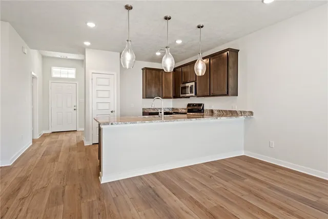 a view of kitchen with granite countertop cabinets and wooden floor