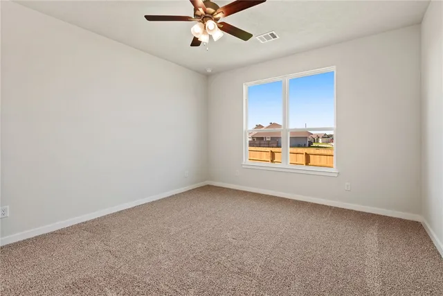 an empty room with a window and a fan