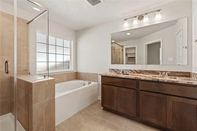 a bathroom with a tub a sink and mirror