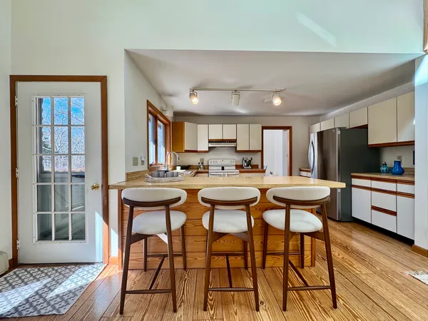 a kitchen with a table chairs refrigerator and cabinets