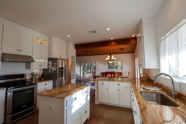 a kitchen with stainless steel appliances a stove a refrigerator a sink a stove and cabinets