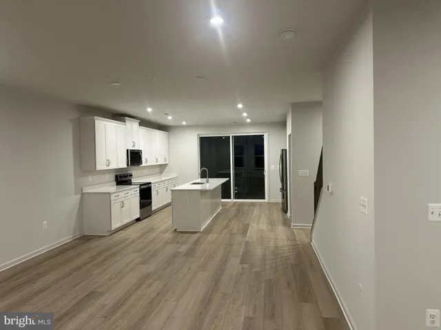 a view of kitchen with sink microwave refrigerator and wooden floor