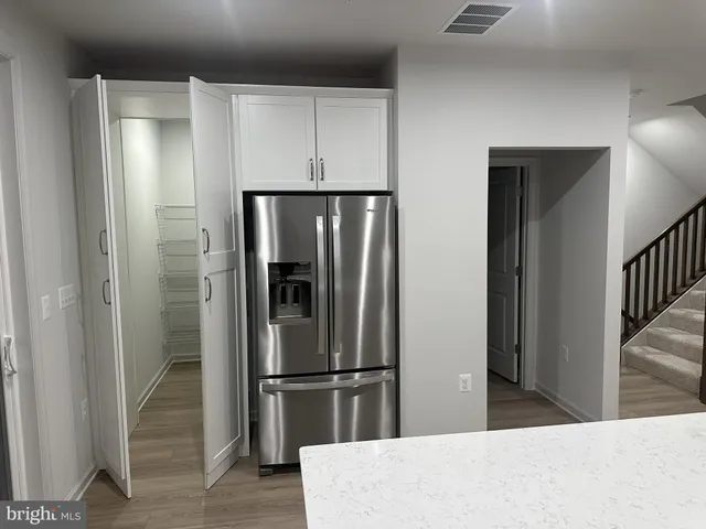 a kitchen with stainless steel appliances a refrigerator and wooden floor