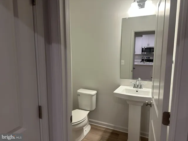 a bathroom with a toilet a sink and mirror