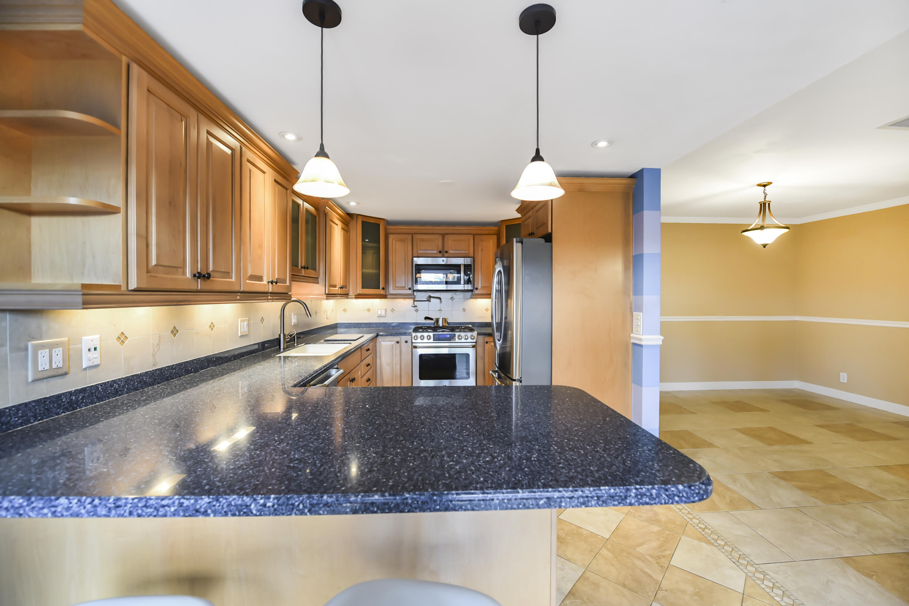 102 Woodland Road Palm Springs, FL 33461 - Photo 12 of 41 a kitchen with kitchen island a counter top space a sink and appliances