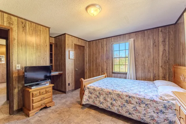 a bedroom with a bed and a dresser with mirror