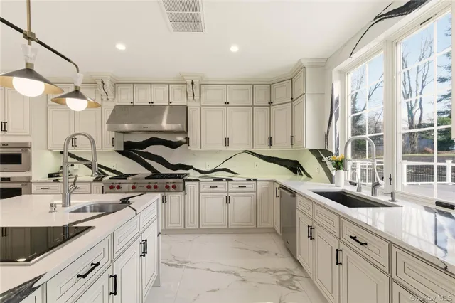 a kitchen with stainless steel appliances granite countertop a sink and a refrigerator