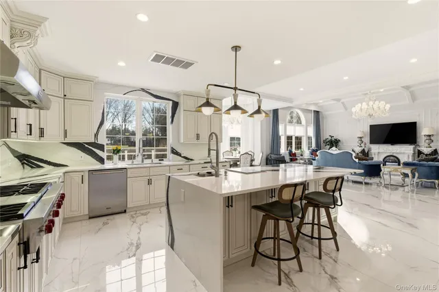 a living room with furniture a chandelier and a flat screen tv