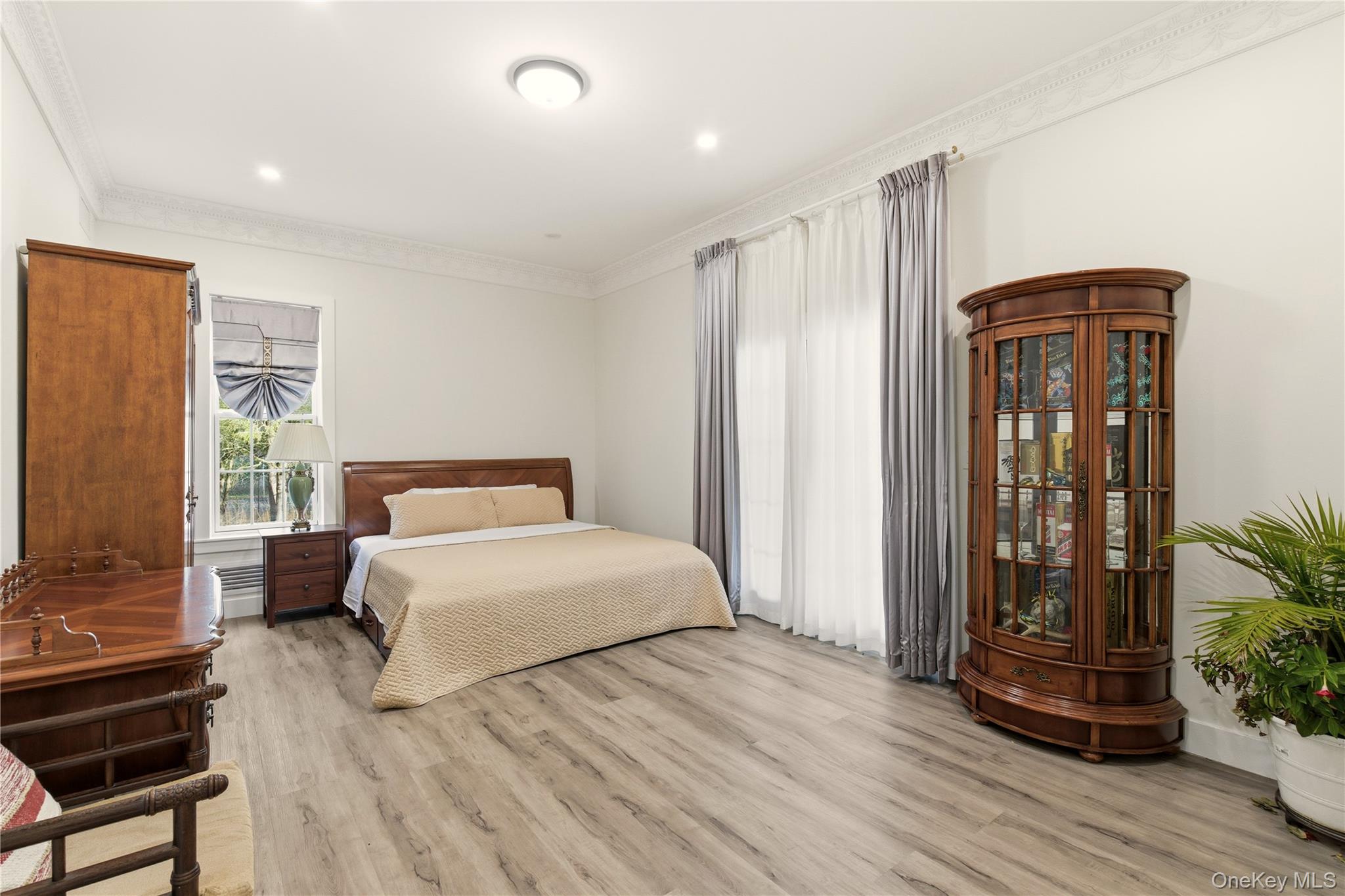 265 Laurel Lane Syosset, NY 11791 - Photo 20 of 48 a bedroom with a bed and a potted plant