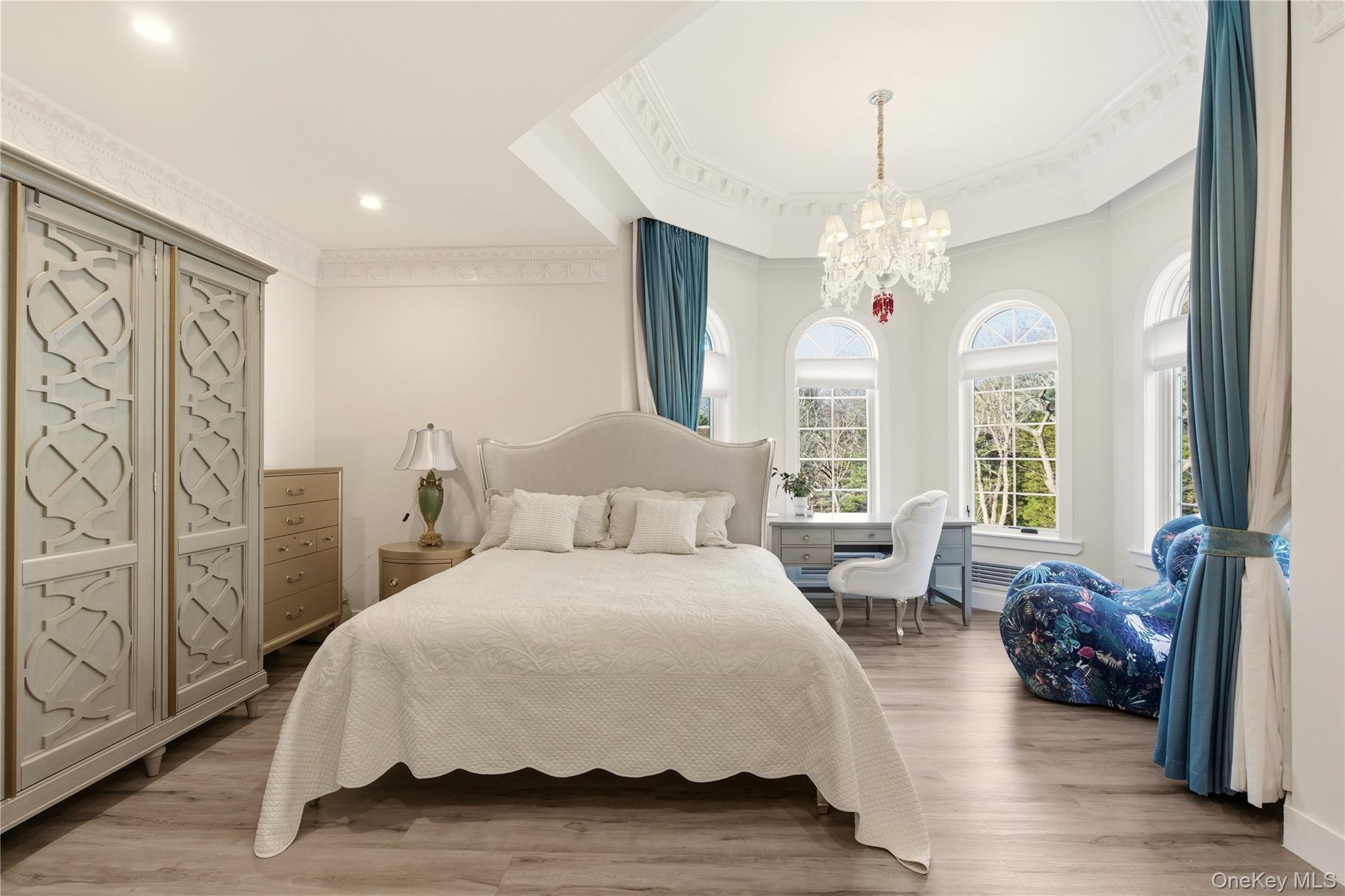 265 Laurel Lane Syosset, NY 11791 - Photo 30 of 48 a spacious bedroom with a bed and a chandelier