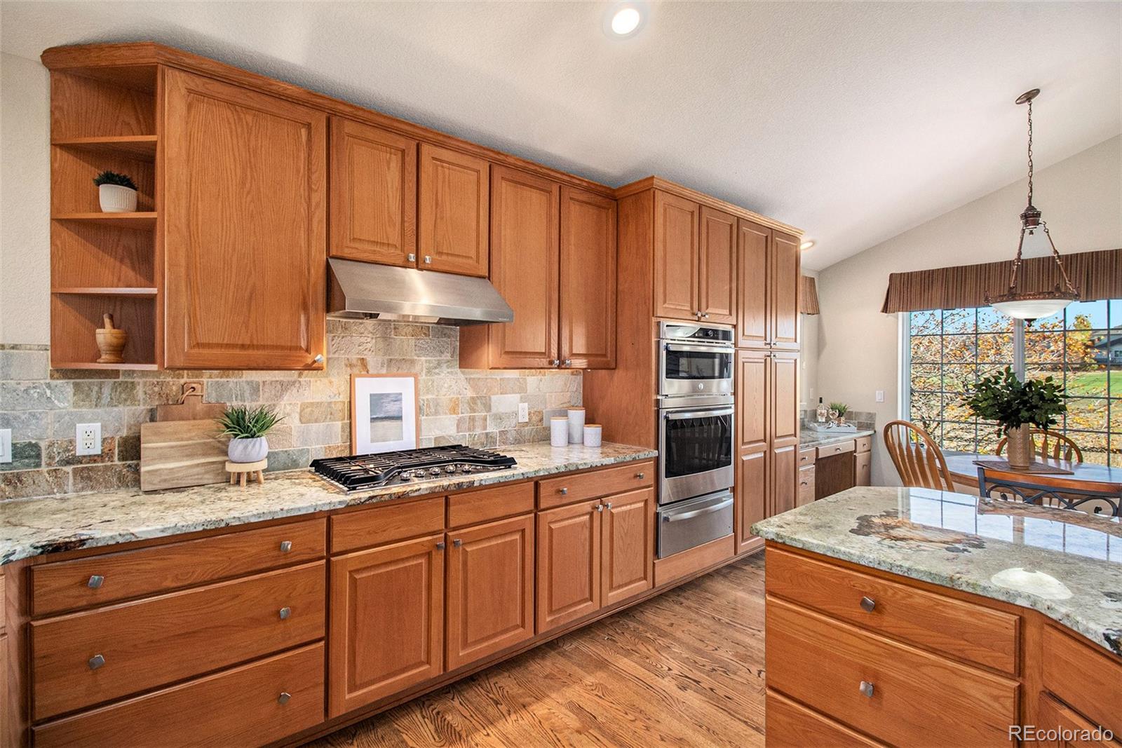10604 Osceola Loop Westminster, CO 80031 - Photo 6 of 32 a kitchen with granite countertop stainless steel appliances a sink counter space cabinets and a large window