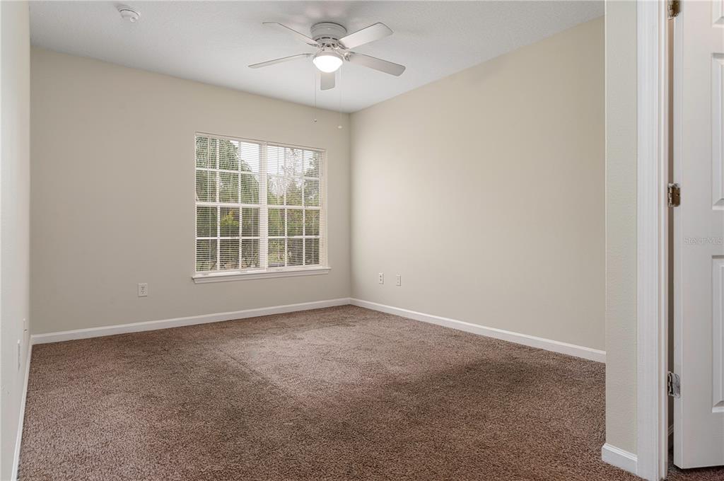 4324 South Kirkman Road, Unit 1103 Orlando, FL 32811 - Photo 11 of 20 an empty room with windows and ceiling fan