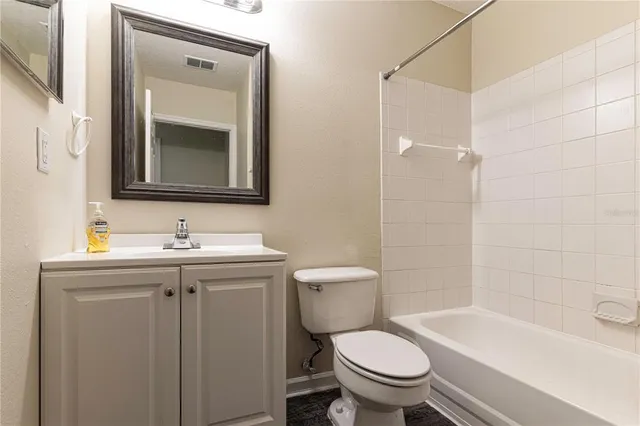 a bathroom with a granite countertop toilet a sink and a mirror