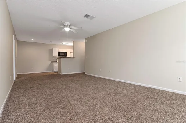 a view of empty room with kitchen and window