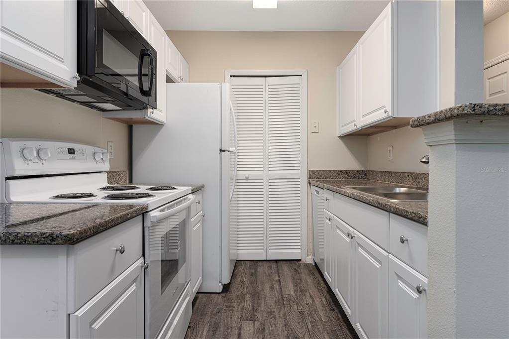 4324 South Kirkman Road, Unit 1103 Orlando, FL 32811 - Photo 7 of 20 a kitchen with stainless steel appliances granite countertop a stove and a sink