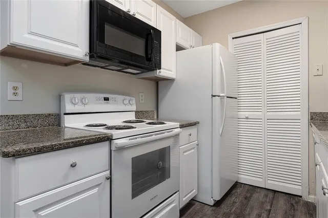 a kitchen with granite countertop a stove and a microwave