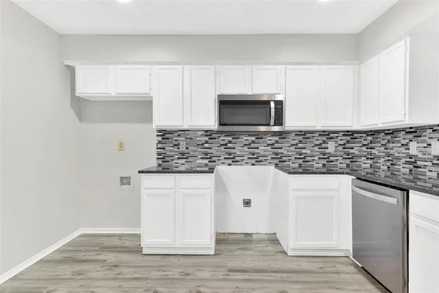 a kitchen with stainless steel appliances a stove a sink and a microwave