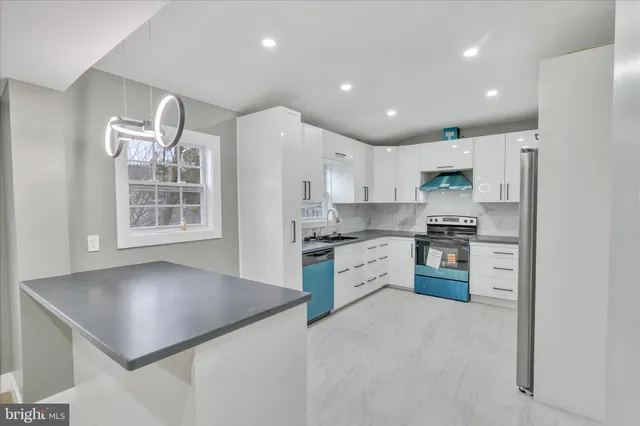 a kitchen with kitchen island white cabinets and stainless steel appliances