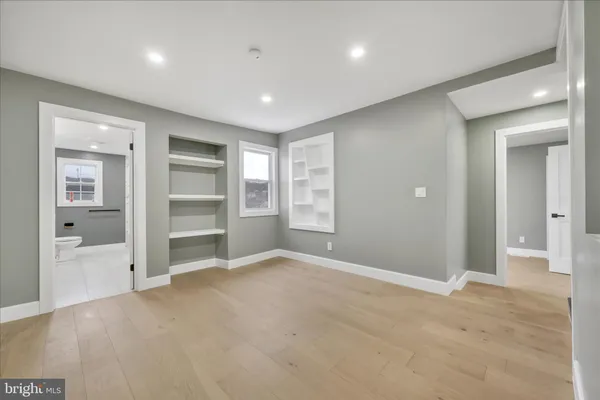 an empty room with closet and windows