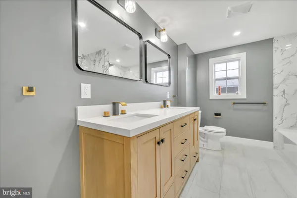 a bathroom with a sink a toilet and a mirror