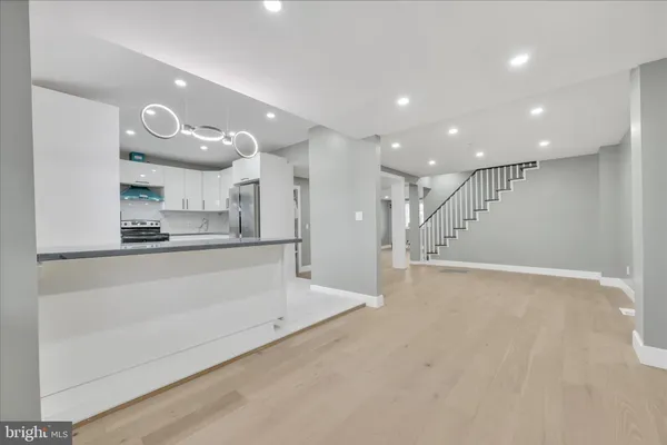 a view of an empty room and kitchen view