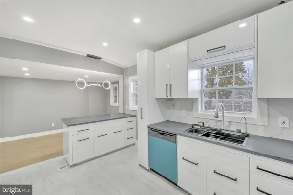 a kitchen with granite countertop a sink stove and cabinets