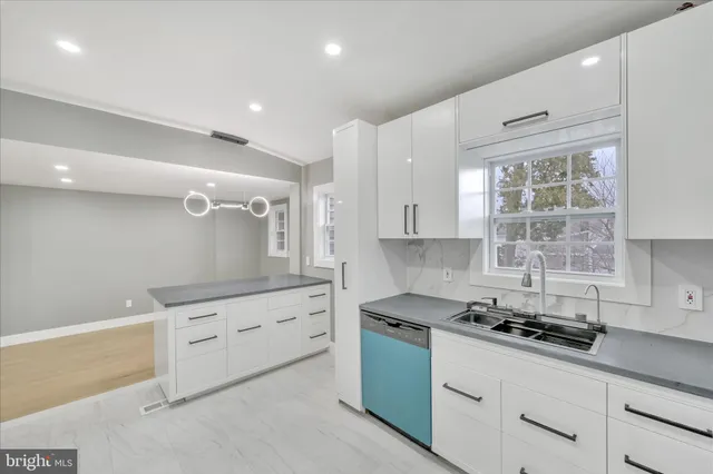 a kitchen with granite countertop a sink stove and cabinets