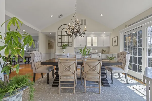 a dining room with furniture potted plants and wooden floor