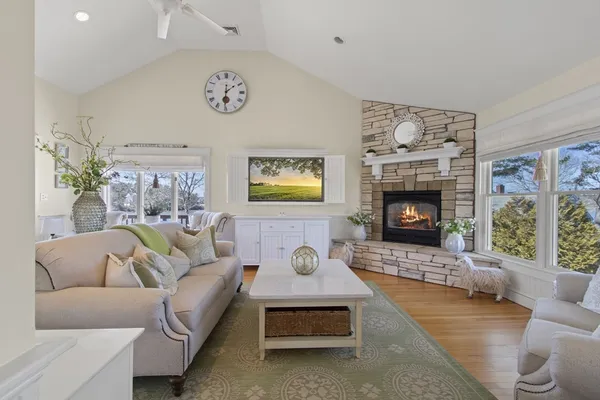 a living room with furniture a large window and a clock
