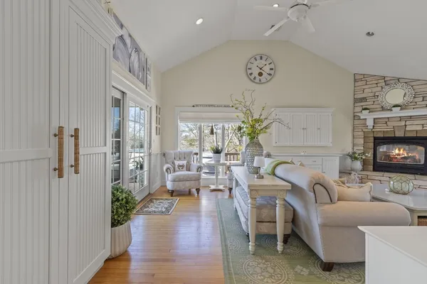 a living room with furniture a fireplace and a floor to ceiling window