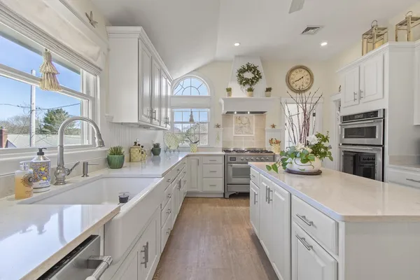 a large white kitchen with cabinets and stainless steel appliances