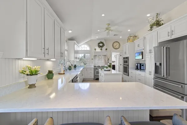a large kitchen with kitchen island stainless steel appliances a sink and cabinets