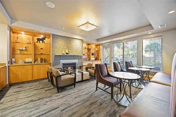 a living room with furniture a fireplace and a floor to ceiling window