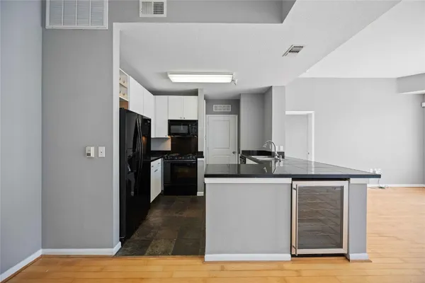 a view of a kitchen with a sink wooden floor and a refrigerator