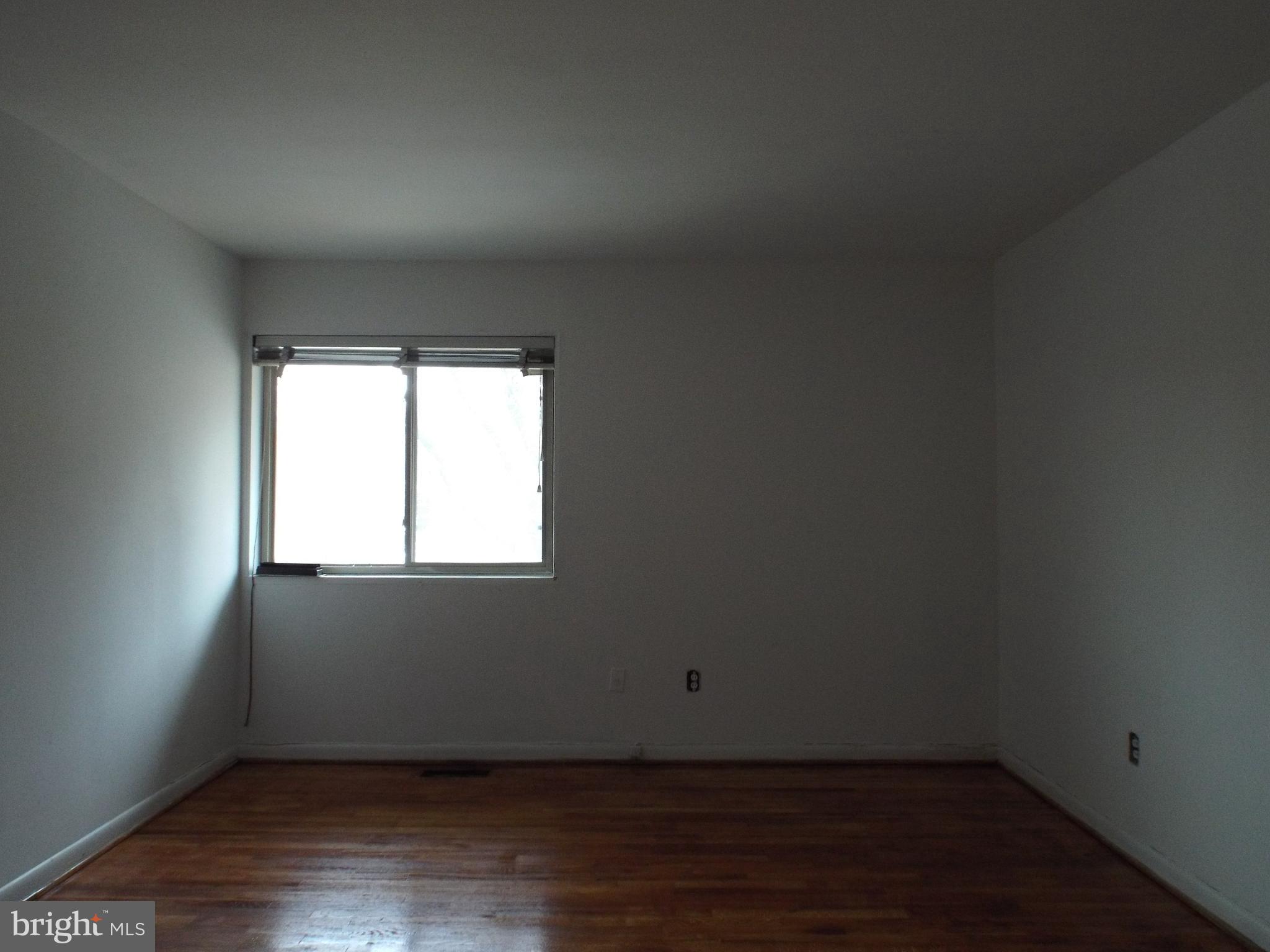 8616 Manchester Road, Unit 5 Silver Spring, MD 20901 - Photo 8 of 16 an empty room with wooden floor and windows