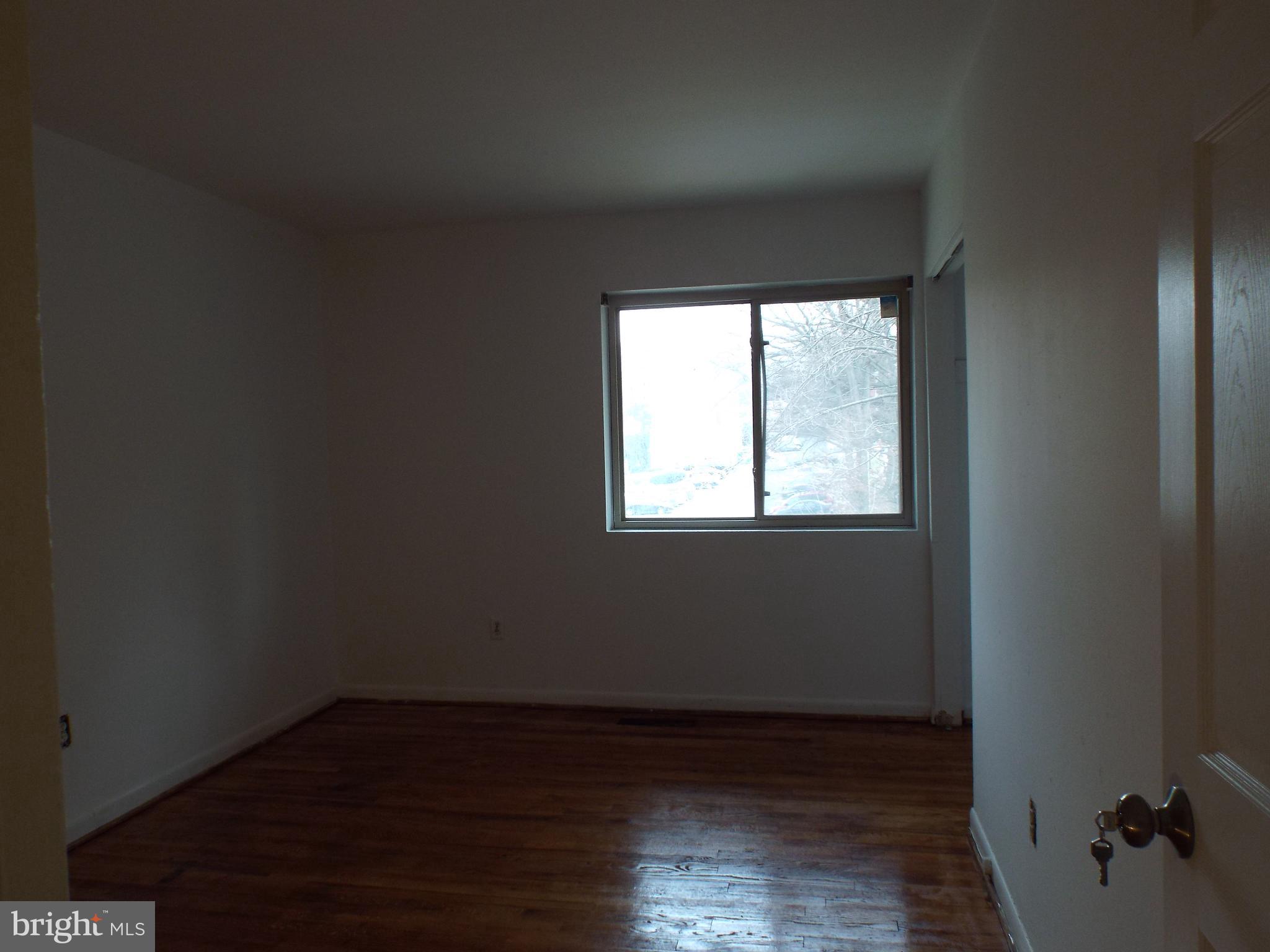 8616 Manchester Road, Unit 5 Silver Spring, MD 20901 - Photo 10 of 16 a view of an empty room with wooden floor and a window