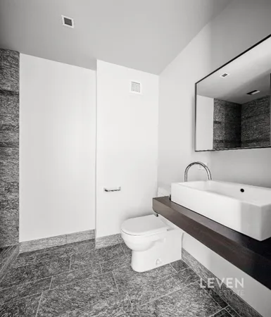 a bathroom with a sink a toilet and mirror