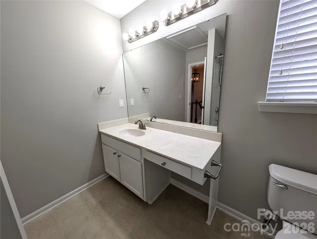 a bathroom with a double vanity sink a toilet and a mirror