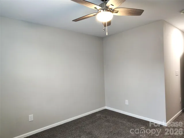 an empty room with a fan and a fan