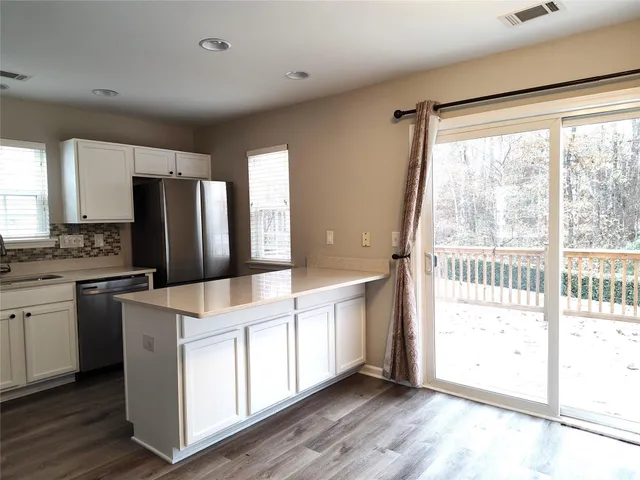 a kitchen with stainless steel appliances a stove top oven and a refrigerator