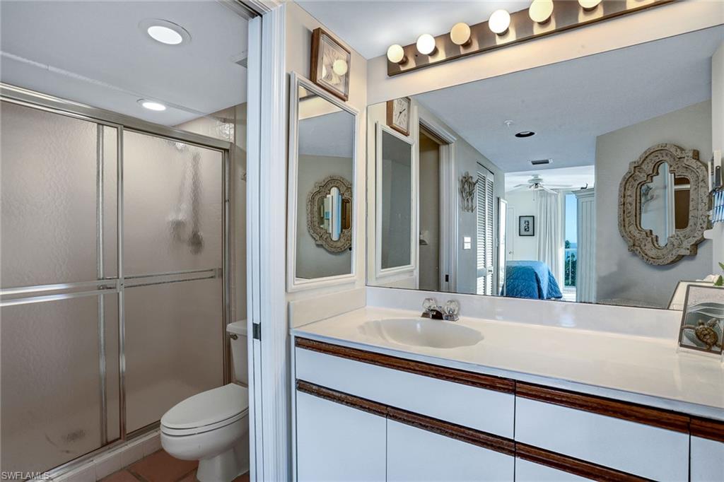 50 Seagate Drive, Unit 402B Naples, FL 34103 - Photo 13 of 26 a bathroom with a sink a toilet and shower