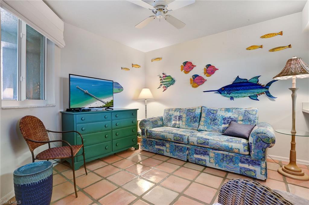 50 Seagate Drive, Unit 402B Naples, FL 34103 - Photo 16 of 26 a living room with furniture and a chair