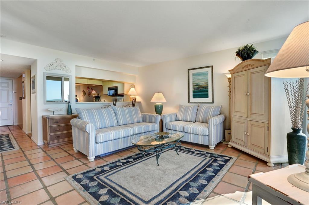 50 Seagate Drive, Unit 402B Naples, FL 34103 - Photo 2 of 26 a living room with furniture and a table