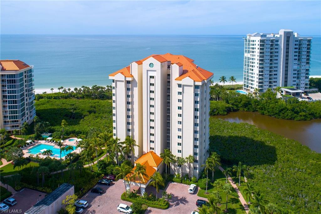 50 Seagate Drive, Unit 402B Naples, FL 34103 - Photo 22 of 26 a view of a multi story residential apartment building with a yard and plants