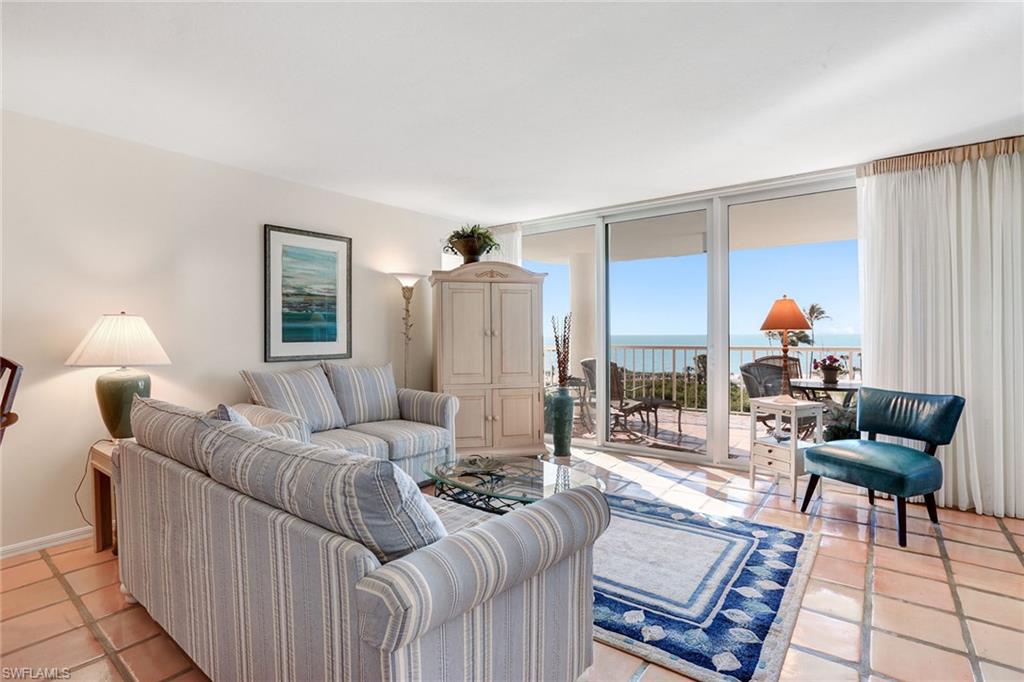 50 Seagate Drive, Unit 402B Naples, FL 34103 - Photo 4 of 26 a living room with furniture and a lamp