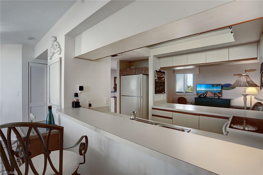 50 Seagate Drive, Unit 402B Naples, FL 34103 - Photo 5 of 26 a living room with furniture and a table