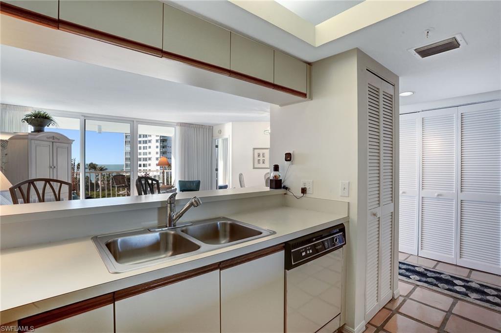 50 Seagate Drive, Unit 402B Naples, FL 34103 - Photo 7 of 26 a kitchen with a sink and cabinets