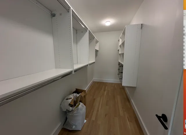 a view of a closet with wooden floor
