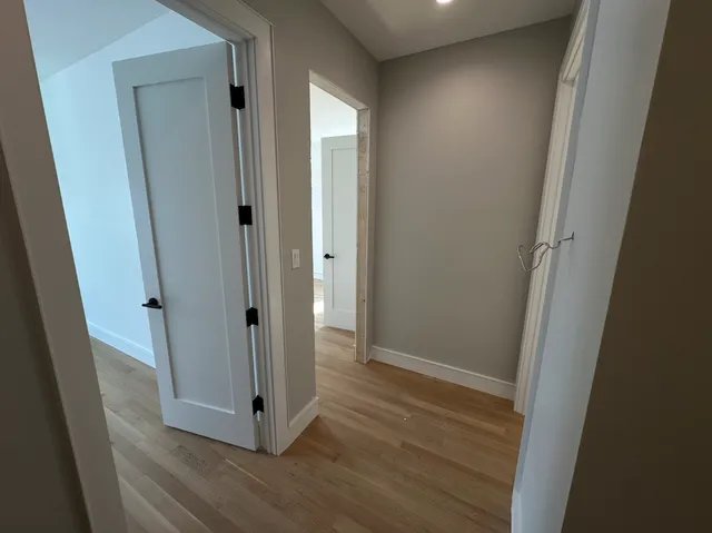a view of a hallway with wooden floor